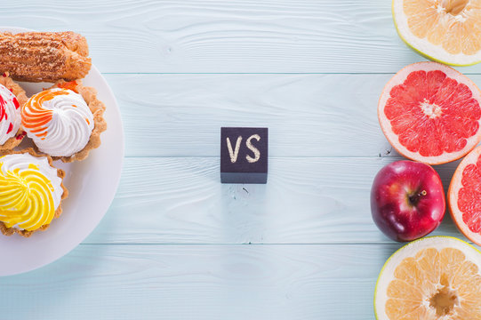 Choosing between Fruits and Sweets. Healthy versus unhealthy food. Weight Loss. Unhealthy tempting cakes and healthy fruits.