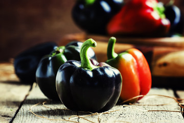 Black bell pepper, vintage wooden background, selective focus