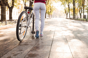 Naklejka premium Cropped photo of woman walking with her bicycle