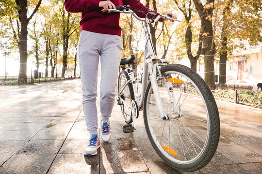 Cropped image of caucasian woman walking with her bicycle