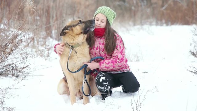 girl and a German shepherd on a winter walk