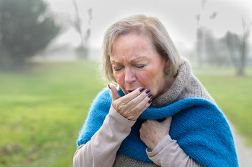 Elderly stylish woman coughing or sneezing
