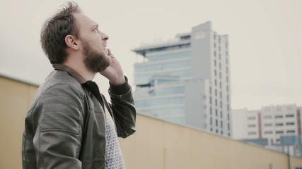 Man talking on the phone standing on the roof, then walks away. hands closeup. 4k