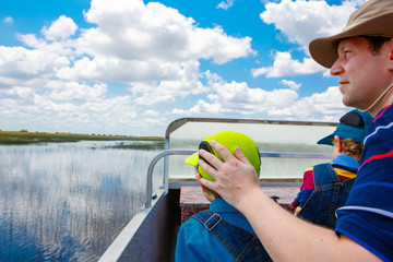 Little kid boy and father making air boat tour in Everglades Park
