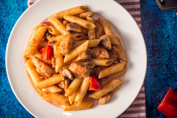 Penne pasta with mushrooms, chicken, tomatoes and cheese parmesa