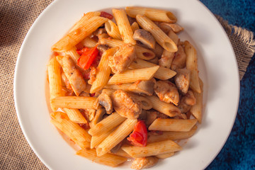 Penne pasta with mushrooms, chicken, tomatoes and cheese parmesa