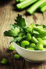 Pieces of fresh celery, vintage wooden background selective focu