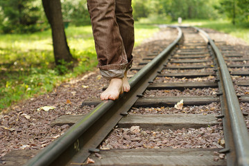 legs of the person going on railway