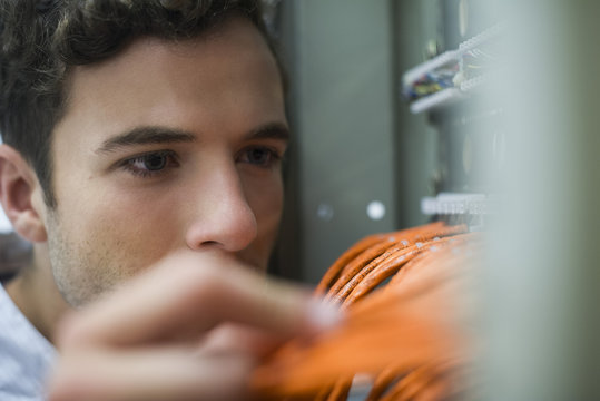Computer technician performing maintenance work on networking equipment