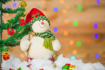 Snowman and gift boxes on bokeh background