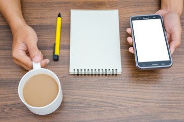Man hands holding phone and holding a hot coffee cup with blank