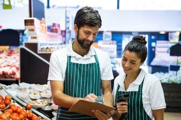 Staff writing on clipboard in organic section
