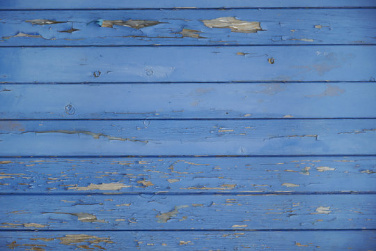 A whole page of wooden floorboards with flaking blue paint background texture