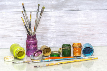 Multicolored plastic cans with paints. Artist workplace background. Old dirty Paints background. Colorful artist palette. Creativity, visual art concept. Art and craft.