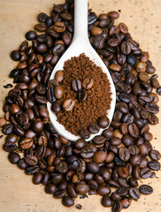 instant coffee in spoon on coffee beans background