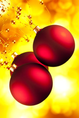 Red Christmas baubles on yellow background