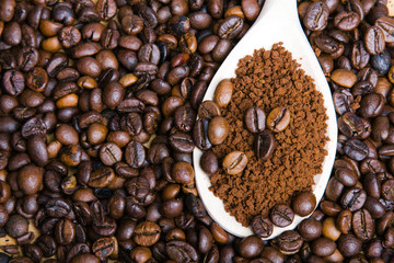 instant coffee in spoon on coffee beans background