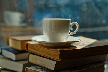 cup of tea, a pile of books on the window
