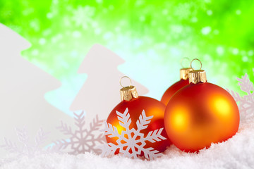 Christmas baubles and trees on green background