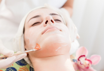 Obraz na płótnie Canvas Face mask.Beautiful young girl at cosmetics getting facial treatment