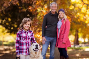 Girl with dog while parents standing at park