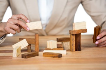 Businesswoman placing wooden block on a tower