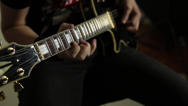 guitarists of a rock band plays on guitar, close-up hands and guitar neck