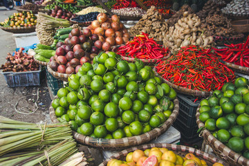 Green limes in basket on fruit market.