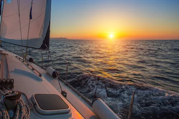 Gordijnen Sailing boat during amazing sunset on the sea. © De Visu