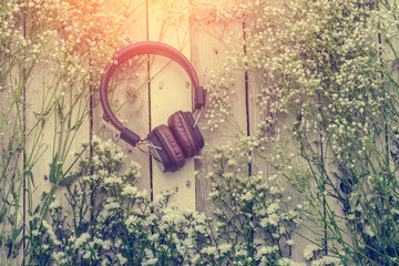 headphone with frame of beautiful flower on wooden background mu