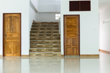 white empty room interior with wooden door and staircase