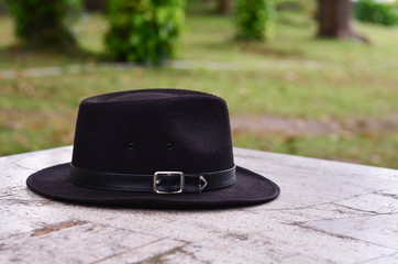 black hat on white background in the garden
