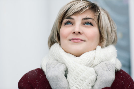 Smiling girl in red coat, and winter clothes - winter hat and wo