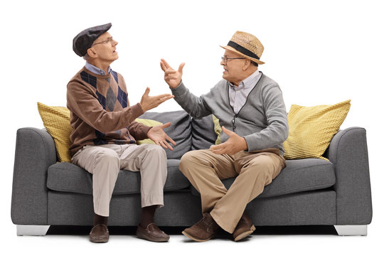 Two elderly men sitting on a sofa and arguing