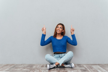 African woman sitting on the floor and showing up