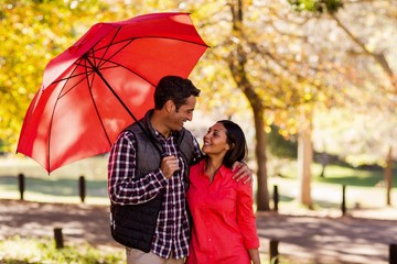 Couple holding umbrella at park