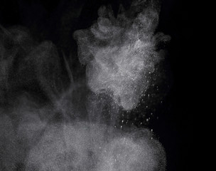 White powder explosion isolated on black background