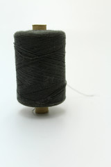 Large spool of gray thread on a white background.