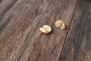 slice half  red apple on wooden background, top view 