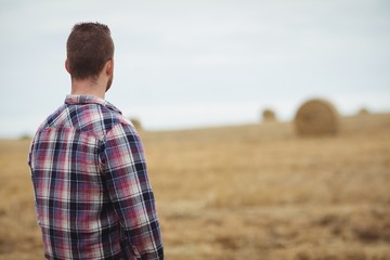 Rear view of farmer standing in field