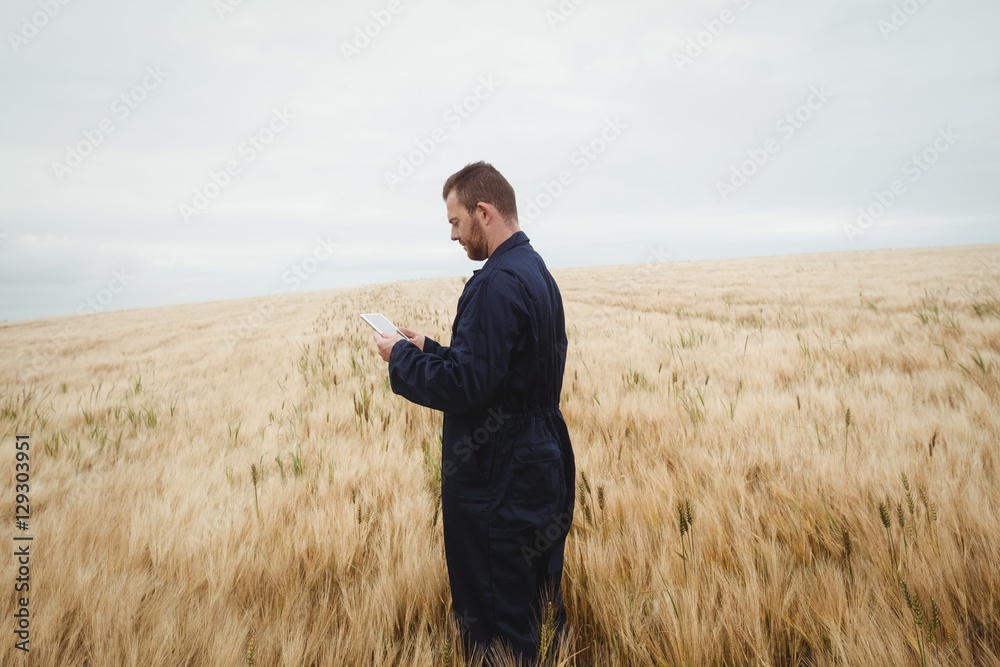Poster Farmer using digital tablet in the field