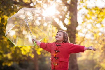 Smiling girl holding umbrella at park