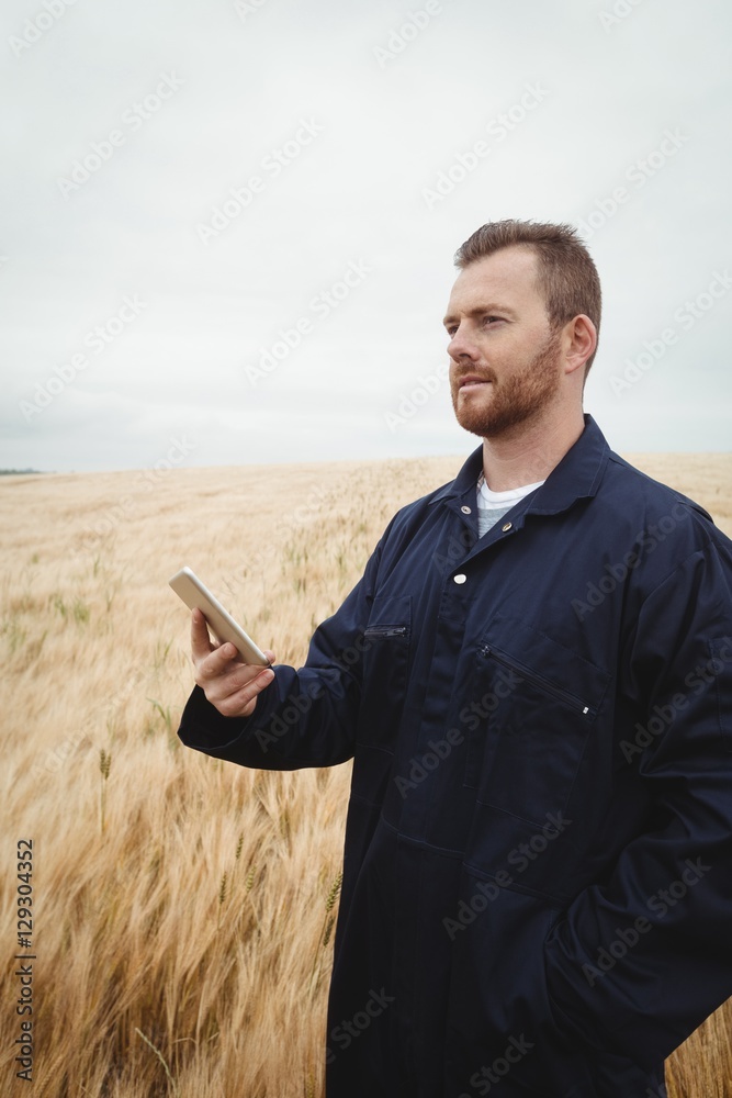 Poster farmer using mobile phone in the field