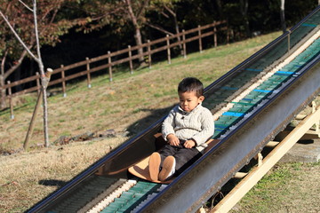 Fototapeta premium 滑り台で遊ぶ幼児(3歳児)