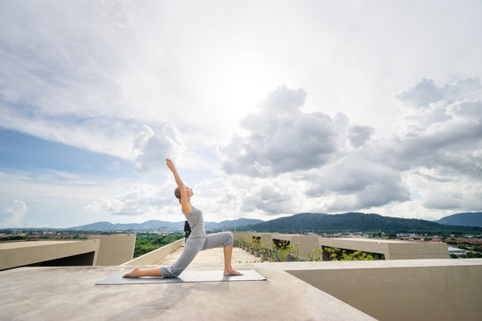 Yoga On Rooftop. Happy Young Woman Stretching On Roof With City And Mountains View.