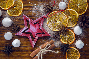 red wooden star lies with dried orange, cinnamon and meringue