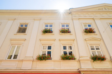 Facade of old europian building with flowers on windows.