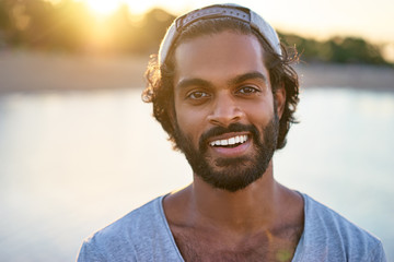 Handsome and confident. Outdoor portrait of smiling young african man at the beach.