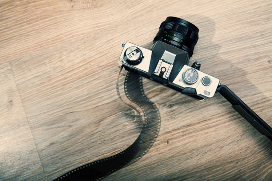 Old analog camera back door and photo film on wood background.  Roll of photographic film. Beautiful vintage design. Photo with Analog design.