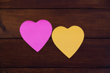Colorful heart shaped paper on wooden board. Mock up for designers.